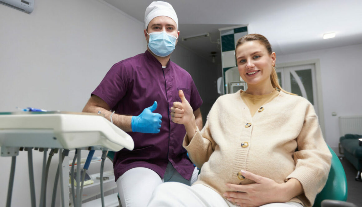 Dentist doctor and pregnant womansmiling, thumbing up looking at camera after dental check-up